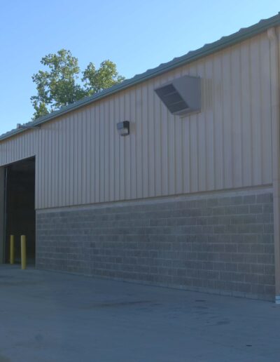 Industrial building with an open bay door on a clear day.