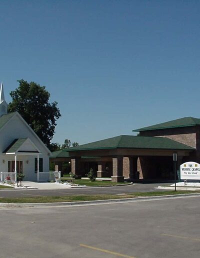 A church with an adjacent building and a clear blue sky in the background.