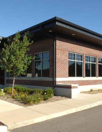 Modern brick commercial building with large windows on a sunny day.